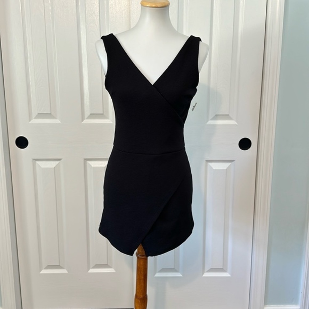 NEW WITH TAGS! Black sleeveless romper. Low cut in back with criss-cross design.